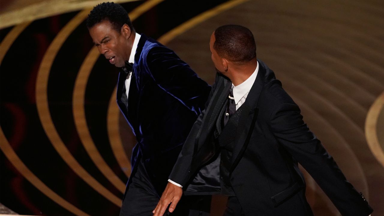 Will Smith, right, hits presenter Chris Rock on stage while presenting the award for best documentary feature at the Oscars on Sunday, March 27, 2022, at the Dolby Theatre in Los Angeles. (AP Photo/Chris Pizzello, File)