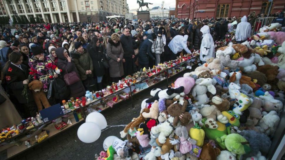 People bring flowers, toys and candles during a day of mourning for the victims of Sunday’s fire in a shopping mall in the Siberian city of Kemerovo, in Manezhnaya square, near the Kremlin in Moscow, Russia, Wednesday, March 28, 2018. (AP Photo/Pavel Golovkin)
