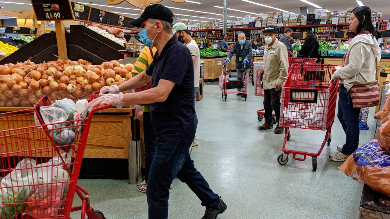 Several customers at Super King Markets grocery store wear face masks and gloves, April 3, 2020, in Los Angeles, as protection against the coronavirus.(AP Photo/Damian Dovarganes)