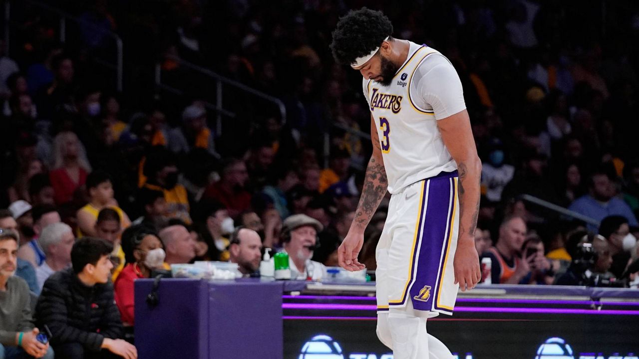 Los Angeles Lakers forward Anthony Davis, right, leaves the game after his ankle seemed to be bothering him during the first half of an NBA game against the Denver Nuggets Sunday in Los Angeles. (AP Photo/Mark J. Terrill)