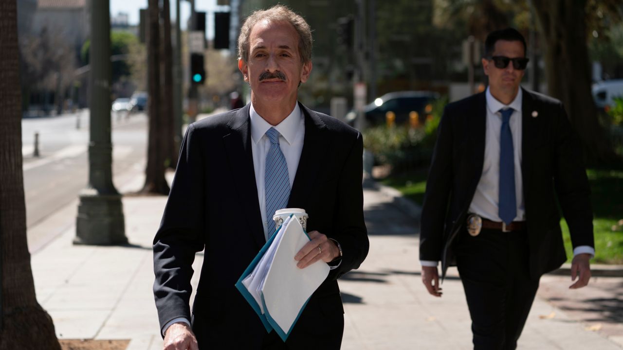 Los Angeles City Attorney Mike Feuer, left, walks back to his office after announcing a lawsuit seeking environmental justice from Monsanto and two related companies for pollution of the City’s waterways with polychlorinated biphenyls at a news conference outside LA City Hall, March 7, 2022. (AP Photo/Damian Dovarganes)