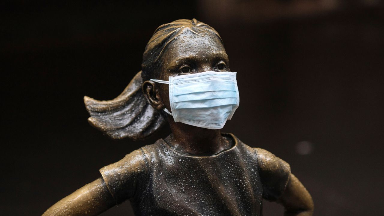 In this file photo from March 19, a surgical mask was placed on the "Fearless Girl" statue outside the New York Stock Exchange in New York. (Kevin Hagen/AP)