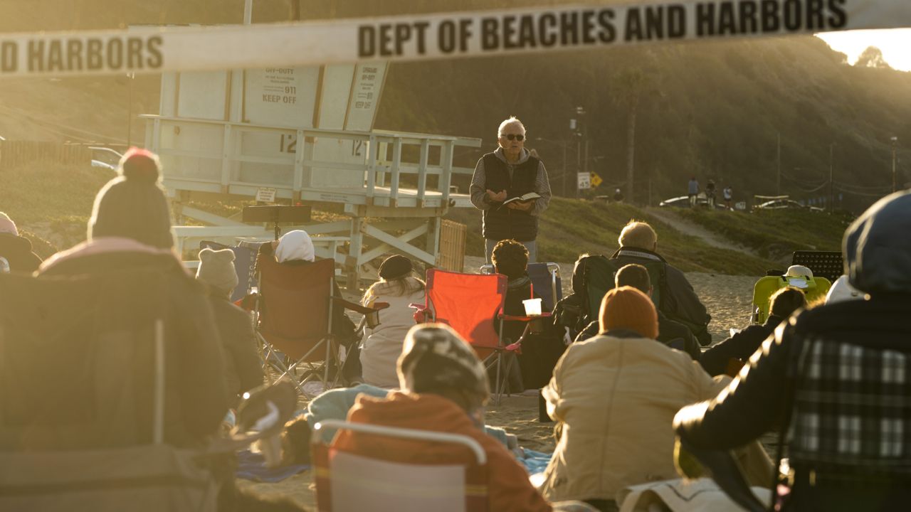 Will Bredberg, pastor at the First Baptist Church of West Los Angeles, preaches during the Westside Easter Sunrise Service at Will Rogers State Beach park on the Santa Monica Bay on the Pacific Coast in the Pacific Palisades neighborhood of Los Angeles Sunday, April 4, 2021. (AP Photo/Damian Dovarganes)