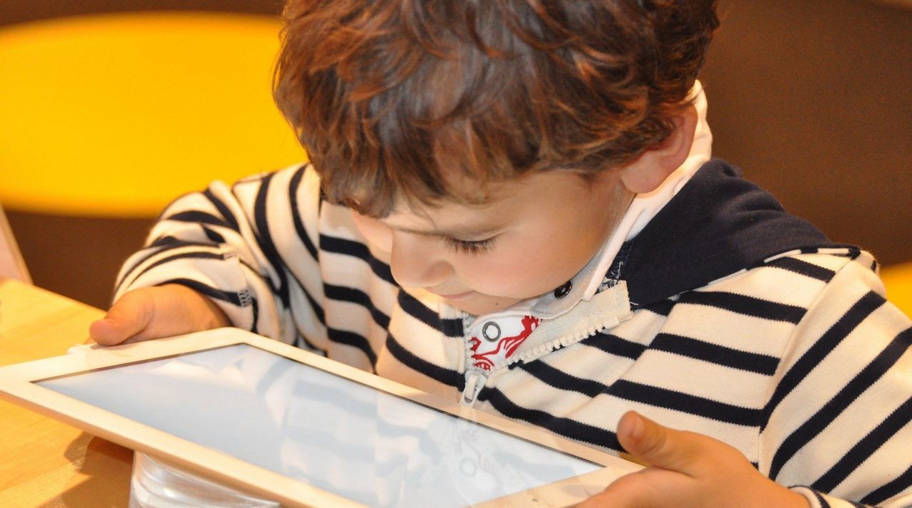 A child looks into a screen of a tablet (Stock image)