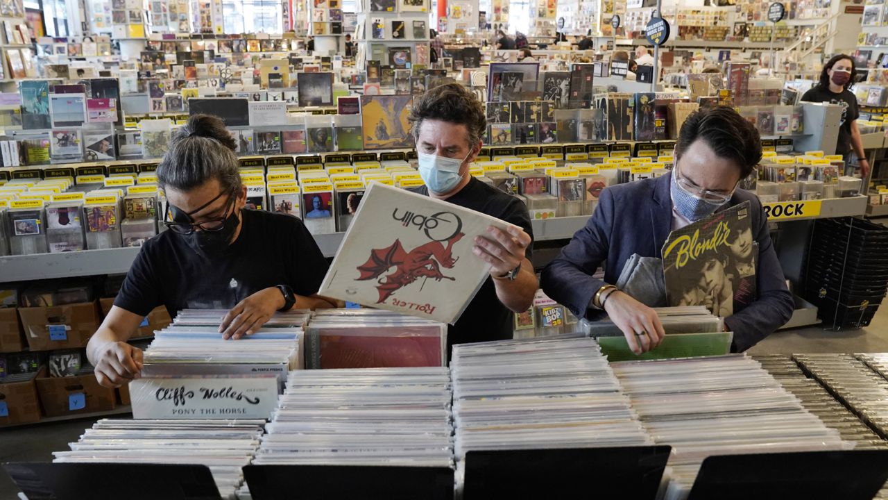 Record shoppers hunt through rare vinyl on the reopening day of the independent record store Amoeba Music Hollywood's new location on Hollywood Blvd., Thursday, April 1, 2021, in Los Angeles. (AP Photo/Chris Pizzello) 