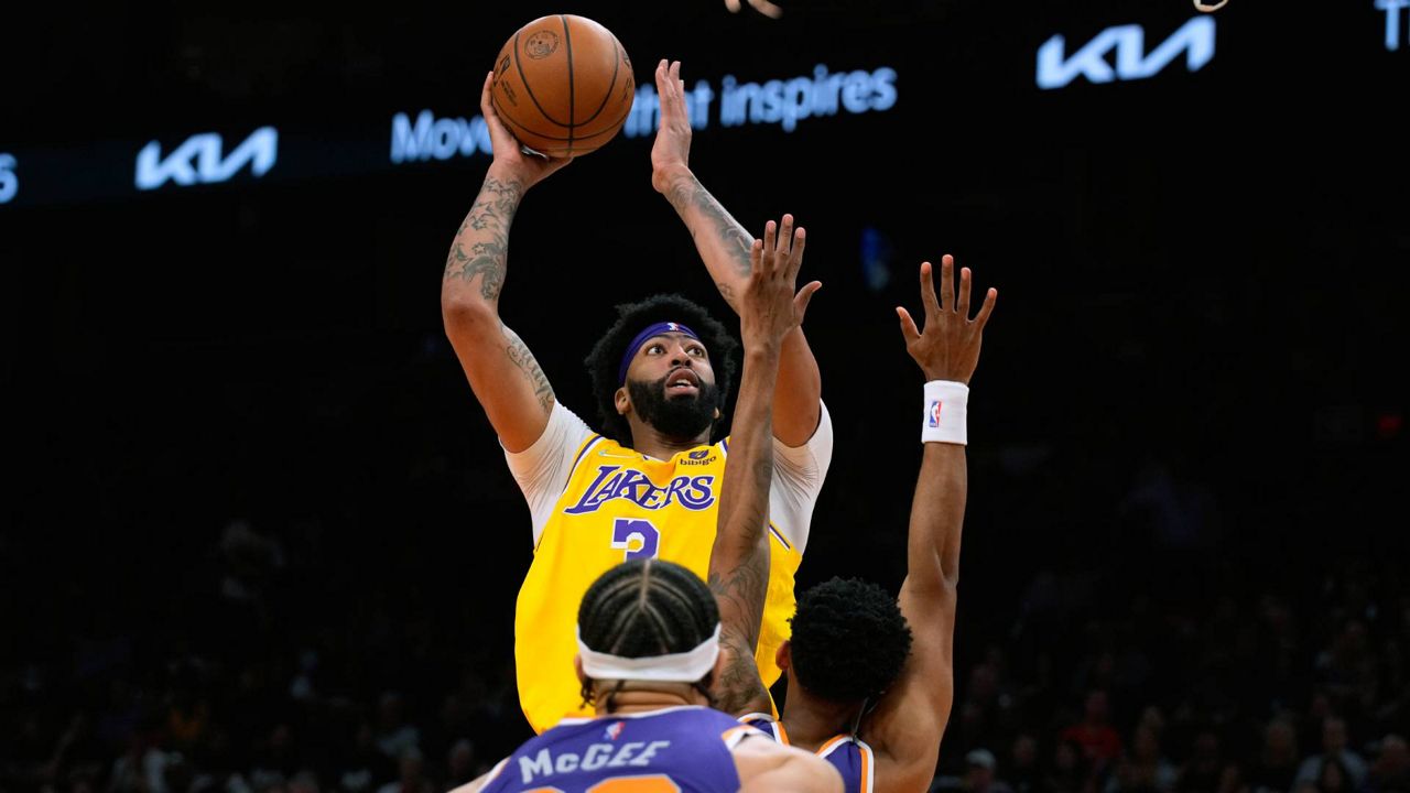 Los Angeles Lakers forward Anthony Davis (3) shoots over Phoenix Suns center JaVale McGee (00) and forward Mikal Bridges during the first half of an NBA game on Tuesday in Phoenix. (AP Photo/Rick Scuteri)