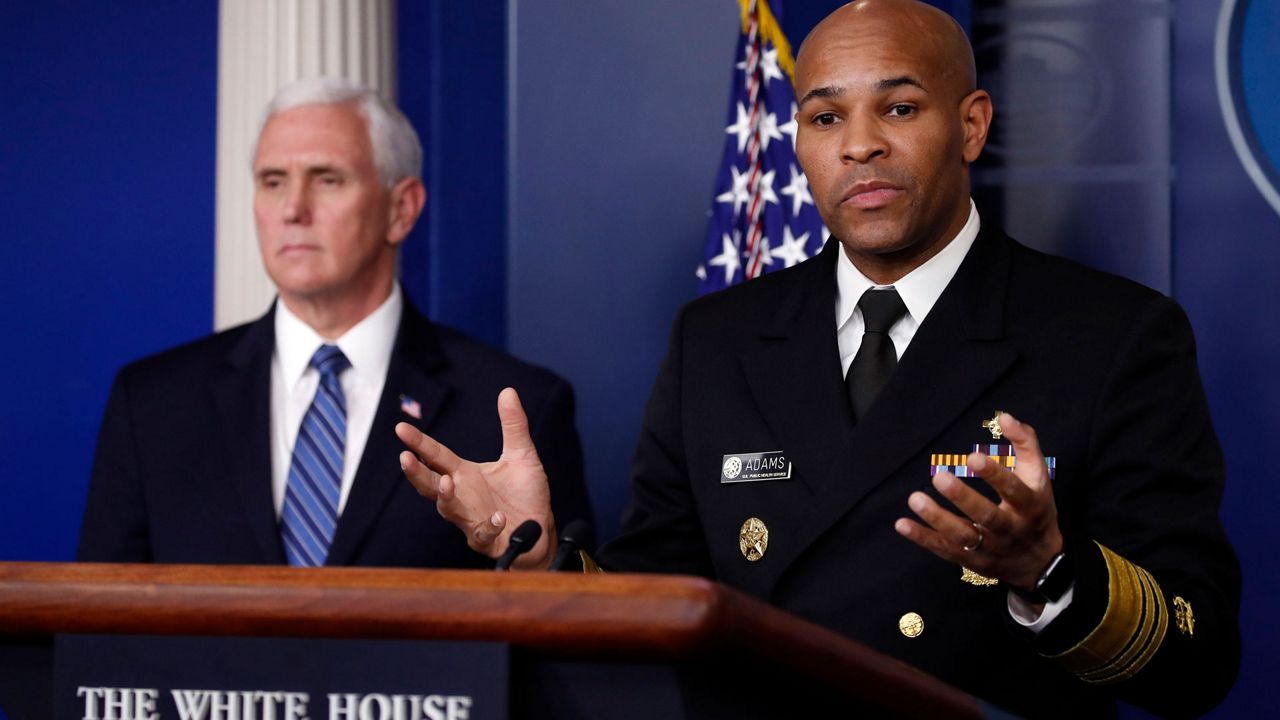 U.S. Surgeon General Jerome Adams speaks about the coronavirus at the White House on Friday in Washington as Vice President Mike Pence listens. (Alex Brandon/AP)
