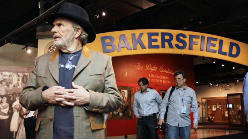 FILE - This file photo shows the late Merle Haggard, left, viewing an exhibit of the Bakersfield sound at the County Music Hall of Fame and Museum in Nashville, Tenn. About 300 people turned out in Bakersfield, California to celebrate the naming of a post office for Merle Haggard. He rose from poverty and prison to international fame through his songs about outlaws, underdogs and an abiding sense of national pride. His hits include "Okie from Muskogee" and " Sing Me Back Home." Norm Hamlet, who played Haggard's band for nearly half-century, told the Bakersfield Californian newspaper that the singer would've been humbled by the honor. (AP Photo/Mark Humphrey, File) 