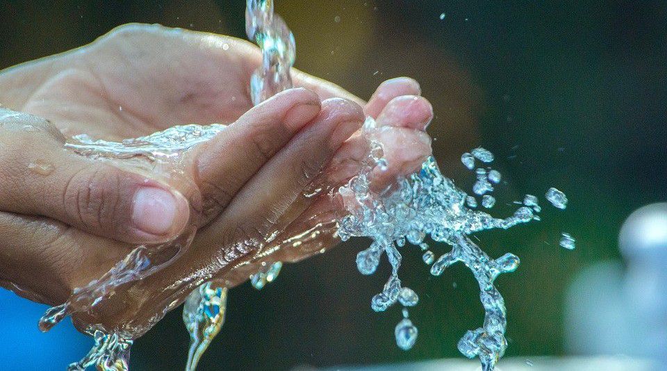 Hands catch splashing water. (Stock image)