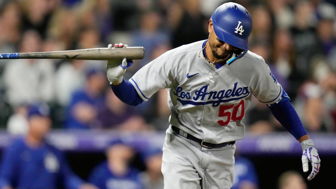Los Angeles Dodgers' Mookie Betts tosses his bat after connecting for an RBI-single in the eighth inning of a baseball game Saturday in Denver. (AP Photo/David Zalubowski)