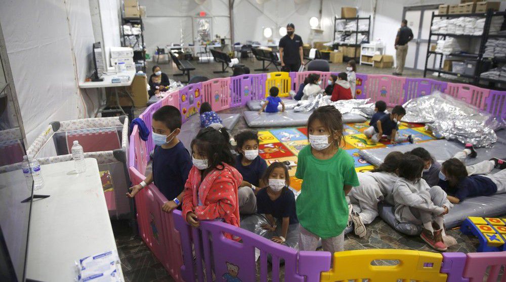 Unaccompanied migrant minors aged 3 to 9, watch a television monitor inside a playpen at the U.S. Customs and Border Protection facility, the main detention center for unaccompanied children in the Rio Grande Valley, in Donna, Texas, on March 30, 2021. (AP Photo/Dario Lopez-Mills, Pool, File)