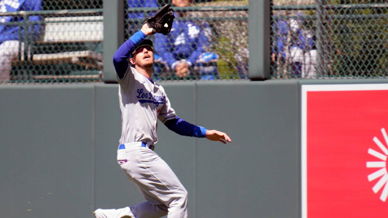 Los Angeles Dodgers center fielder Cody Bellinger pulls in a fly ball off the bat of Colorado Rockies' Garrett Hampson in the second inning of a baseball game Sunday in Denver. (AP Photo/David Zalubowski)