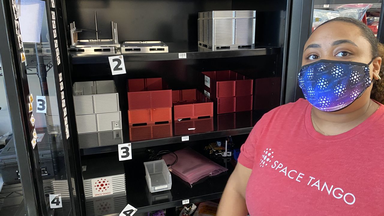 Space Tango Communications Manager Danielle Rosales stands in front of the the company’s CubeLabs, which provide a standardized platform for research and development on the International Space Station U.S. National Laboratory. (Brandon Roberts/Spectrum News 1 KY)