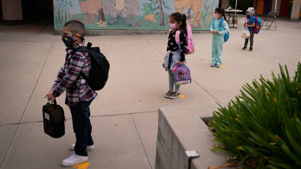 In this April 13, 2021, file photo, socially distanced kindergarten students wait for their parents to pick them up on the first day of in-person learning at Maurice Sendak Elementary School in Los Angeles, April 13, 2021. (AP Photo/Jae C. Hong)