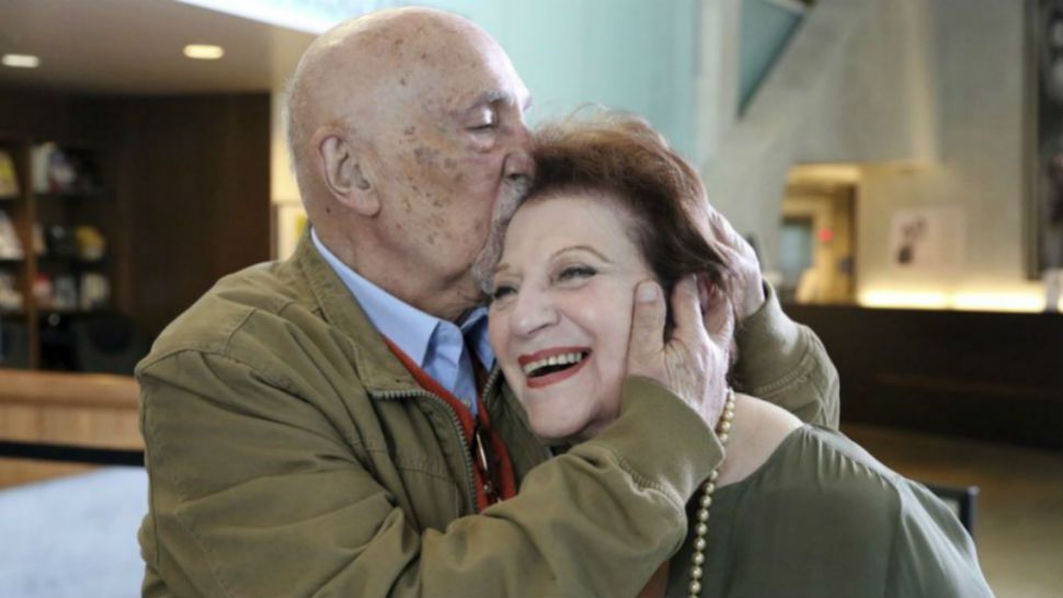 In this Wednesday, April 11, 2018, photo, childhood Holocaust survivors Simon Gronowski and Alice Gerstel Weit embrace at the Los Angeles Holocaust Museum. When the Nazis arrived, Gronowski’s father was in a hospital. His wife quickly lied, telling them he was dead and sparing him from Auschwitz. It was on a train to that death camp a few weeks later that she saved her son, pushing him toward the door of the boxcar they were in and telling him to jump. (AP Photo/Reed Saxon)