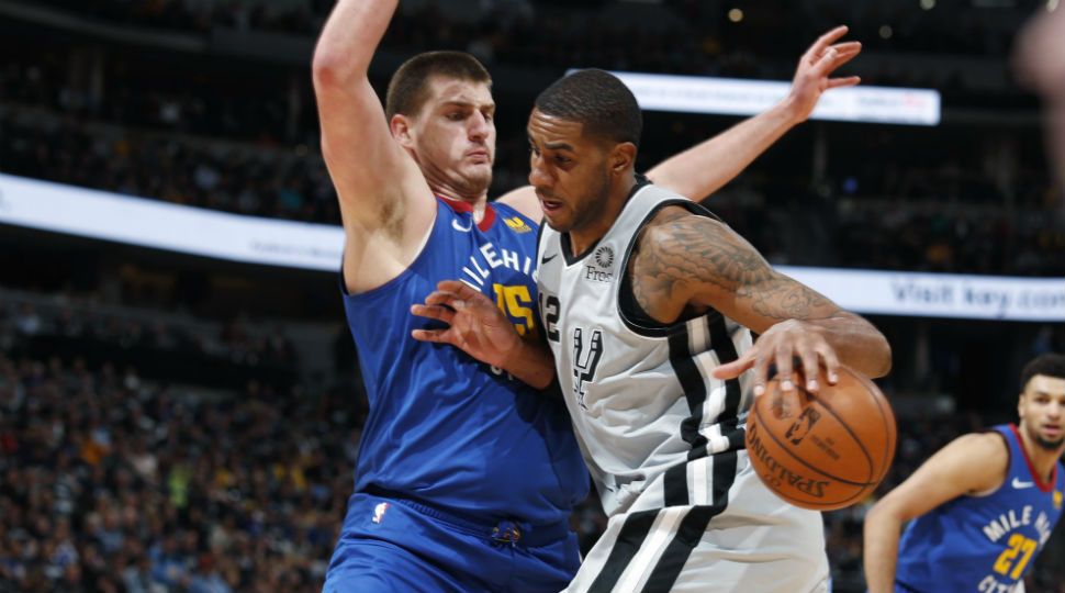 San Antonio Spurs center LaMarcus Aldridge, front, drives into Denver Nuggets center Nikola Jokic during the first half of Game 1 of an NBA first-round basketball playoff series April 13, 2019, in Denver. (AP Image)