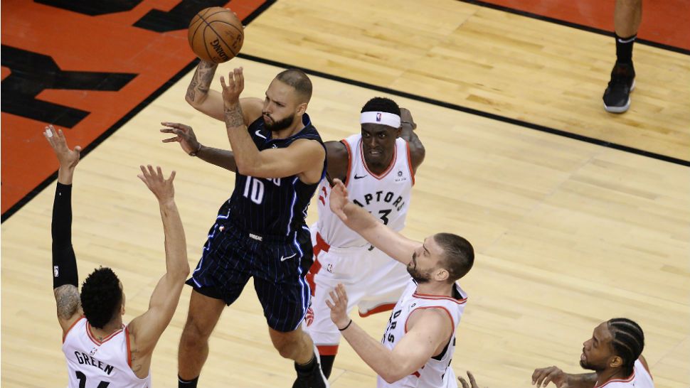 Orlando Magic guard Evan Fournier (10) goes to net as he's surrounded by Toronto Raptors guard Danny Green (14), forward Pascal Siakam (43) center Marc Gasol (33) and forward Kawhi Leonard (2) during the second half of Game 2 of an NBA basketball first-round playoff series Tuesday, April 16, 2019, in Toronto. (Nathan Denette/The Canadian Press via AP)