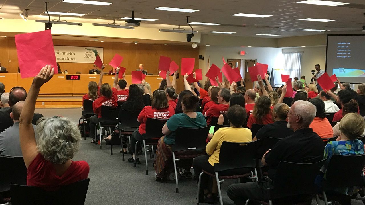 People who attended had red and green sheets of paper to show school board members their feelings about arming school personnel. (Krystel Knowles, staff)