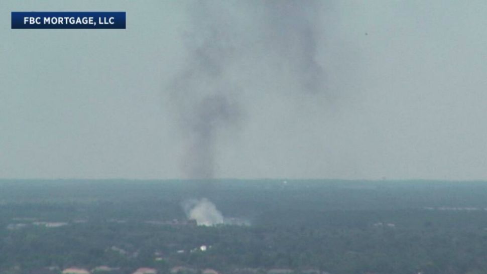 A grass fire sends up a plume of smoke near Orlando International Airport on Tuesday afternoon that could be seen from downtown Orlando. (Sky 13 camera)