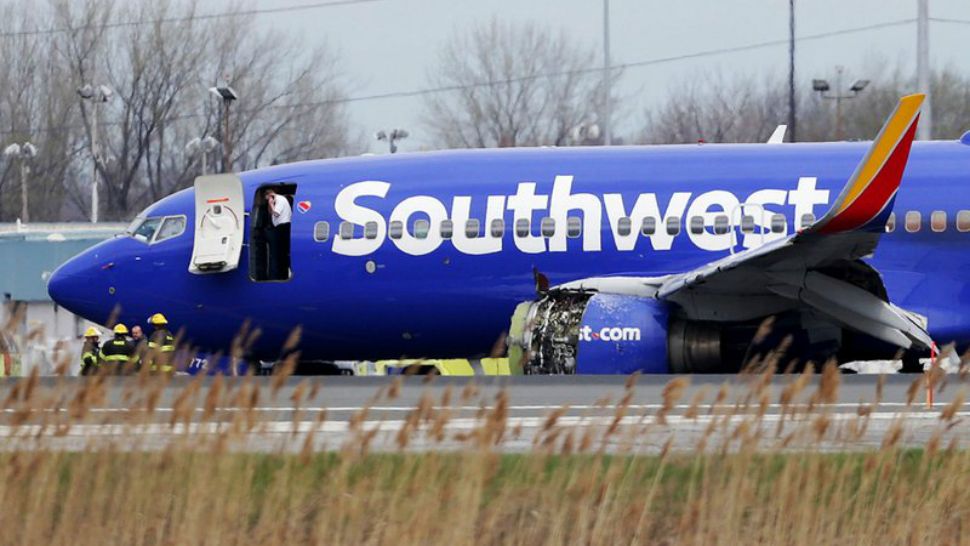 A Southwest jet sits on the runway with a damaged engine at Philadelphia International Airport on Tuesday after it made an emergency landing. (David Maialetti, The Philadelphia Inquirer via the Associated Press)