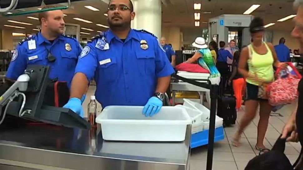 In this file photo from August 2014, TSA workers check luggage at Orlando International Airport. (Spectrum News 13 file)