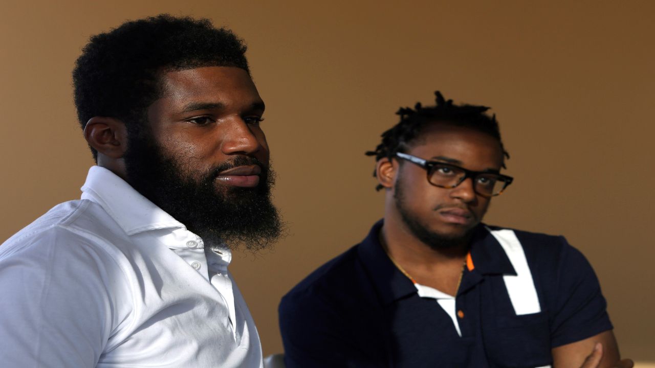 Rashon Nelson, left, and Donte Robinson, right, listen to a reporter's question during an interview with The Associated Press