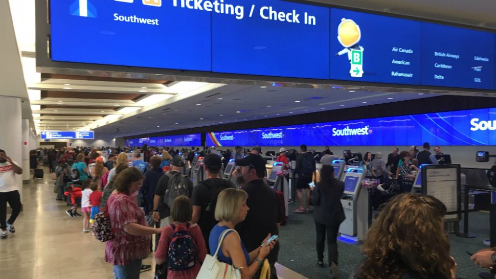 Travelers jam the Southwest ticketing counter at Orlando International Airport because of delayed flights due to bad weather Friday. (Greg Angel/Spectrum News 13)