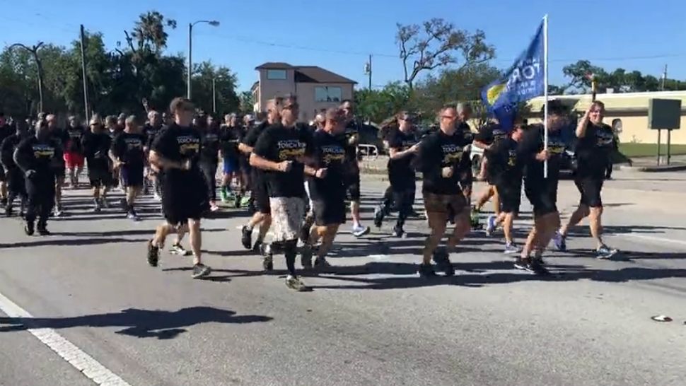 In this file image from Tuesday, members of law enforcement from the Orlando area, including Orange County deputies and Orlando Police, participate in the area's Torch Run, which raises money for Special Olympics Florida. (Spectrum News 13)