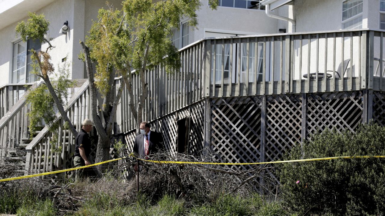 San Luis Obispo Sheriff's Office personnel search under the deck in the backyard of the home of Ruben Flores, Tuesday, March 16, 2021, in Arroyo Grande, Calif. (AP Photo/Daniel Dreifuss)