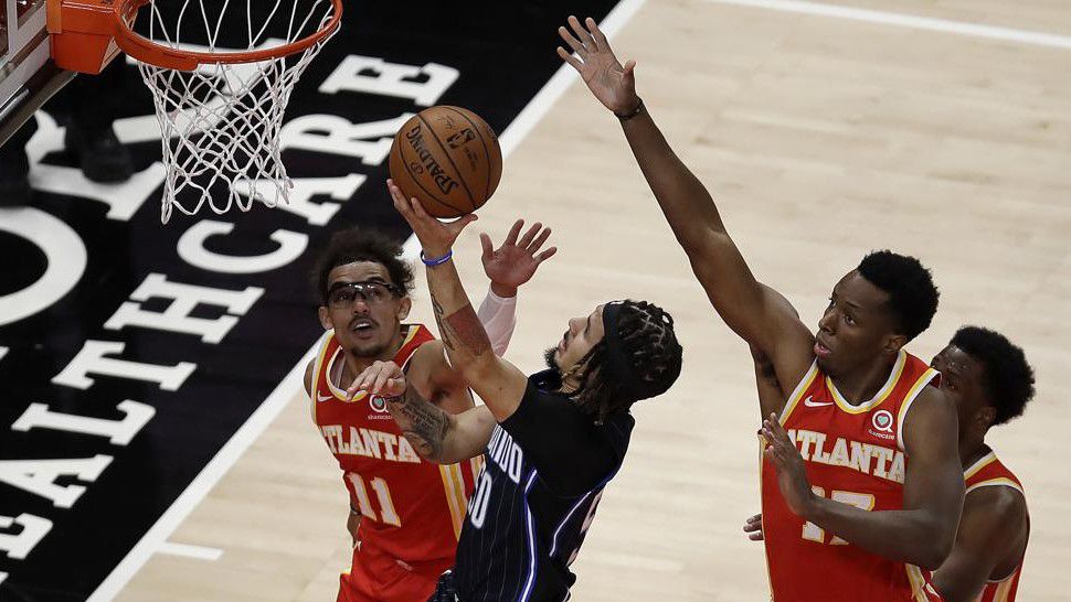 Orlando Magic guard Cole Anthony, center, shoots against Atlanta Hawks' Trae Young (11) and Onyeka Okongwu (17) in the first half of an NBA basketball game Tuesday, April 20, 2021, in Atlanta. (AP ...