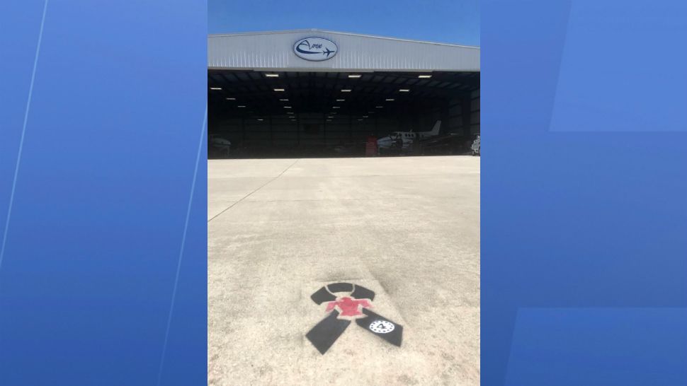 A painted emblem pays tribute to fallen Air Force Maj. Stephen Del Bagno, whose jet designation was No. 4, in front of a jet center at Orlando Melbourne International Airport. (Greg Pallone, Spectrum News 13)