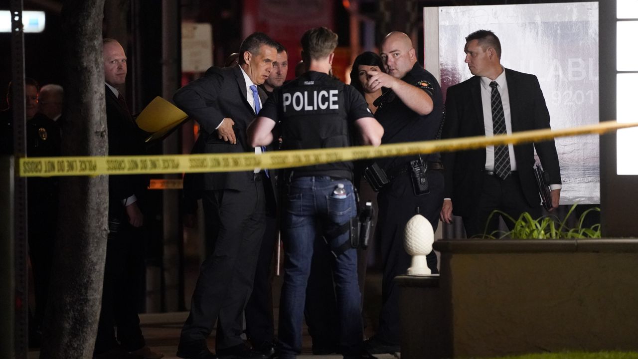 Investigators gather outside an office building where a shooting occurred in Orange, Calif., Wednesday, March 31, 2021. (AP Photo/Jae C. Hong)