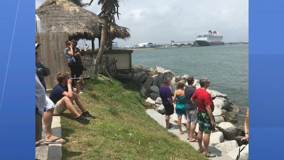Dozens of onlookers watch the 1st-stage booster of the Falcon 9 rocket that carried NASA's TESS satellite return to Port Canaveral on Saturday afternoon.