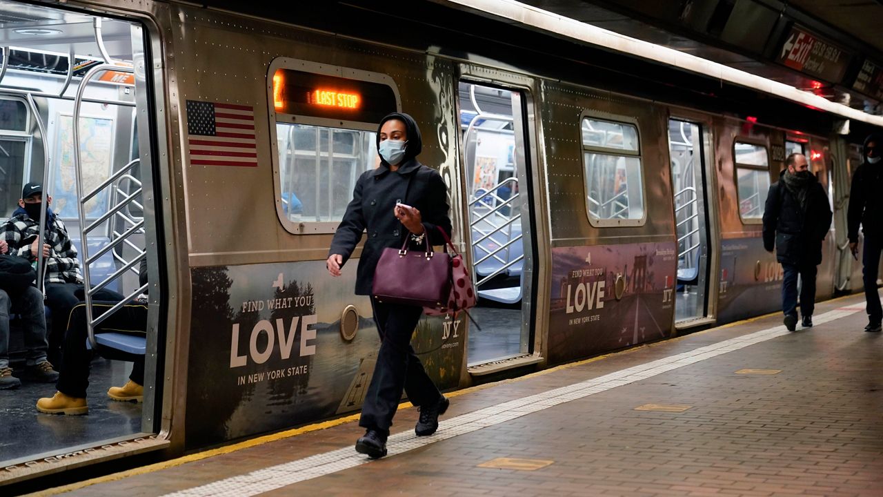 An April 22, 2021, file photo of a commuter walking through the Jamaica Center subway station