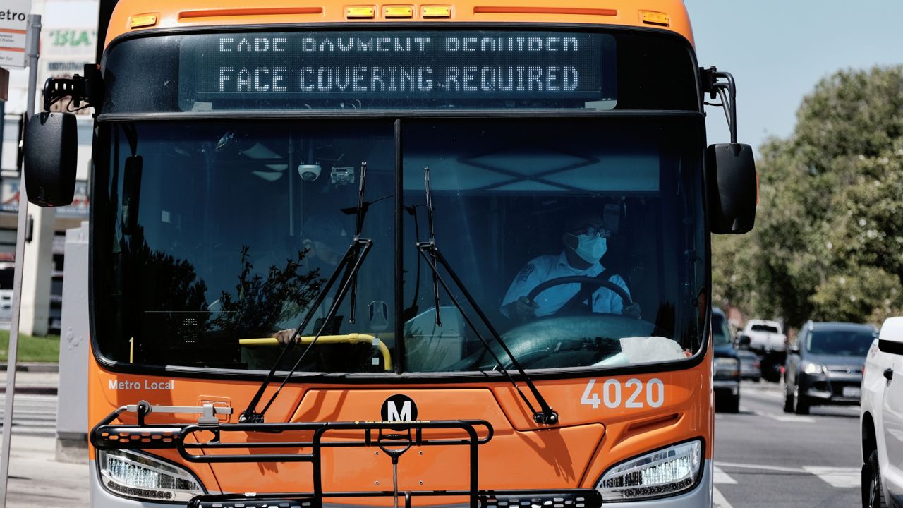 A Los Angeles Metro bus with an electronic display requiring a face mask is seen as the driver pulls out of a bus stop in Los Angeles on April 19, 2022. (AP Photo/Richard Vogel)