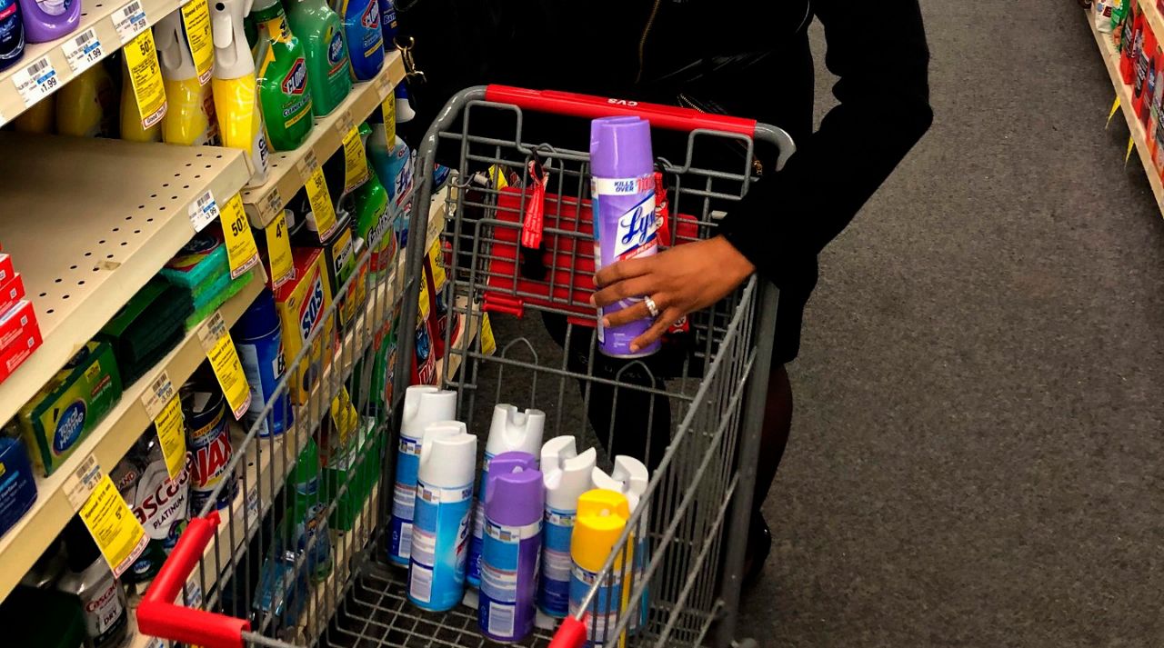 A woman stocks up on Lysol disinfectant spray Tuesday, March 3, 2020, at a CVS near downtown Detroit. (AP Photo/Corey Williams)