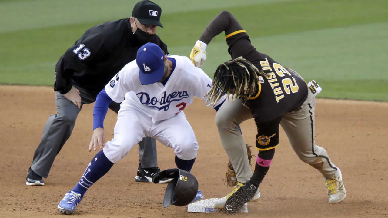 San Diego Padres' Fernando Tatis Jr., right, steals second as Los Angeles Dodgers second baseman Chris Taylor applies the late tag with umpire Todd Tichenor, left, watching during the sixth inning of a baseball game in Los Angeles, Sunday, April 25, 2021. (AP Photo/Alex Gallardo)