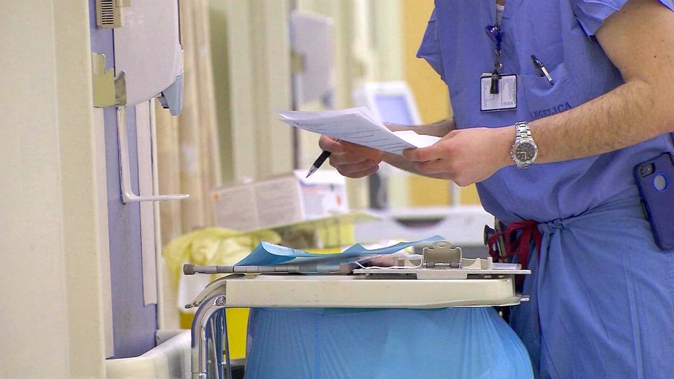 Doctor looks at papers in a hospital hallway (File photo)