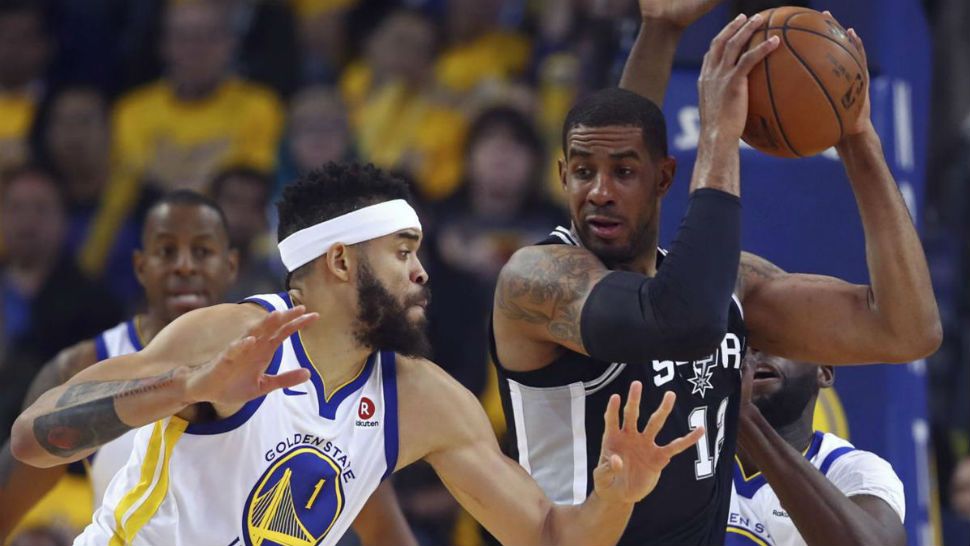 San Antonio Spurs' LaMarcus Aldridge, center, looks to pass the ball away from Golden State Warriors' JaVale McGee (1) and Draymond Green (23) during the first quarter in Game 5 of a first-round NBA basketball playoff series Tuesday, April 24, 2018, in Oakland, Calif. (AP Photo/Ben Margot)
