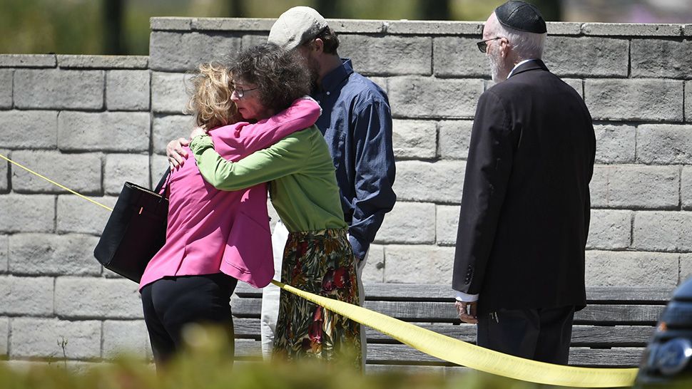 Synagogue members console one another outside of the Chabad of Poway Synagogue Saturday, April 27, 2019, in Poway, Calif. Several people were injured in a shooting at the synagogue. (AP Photo/Denis Poroy)