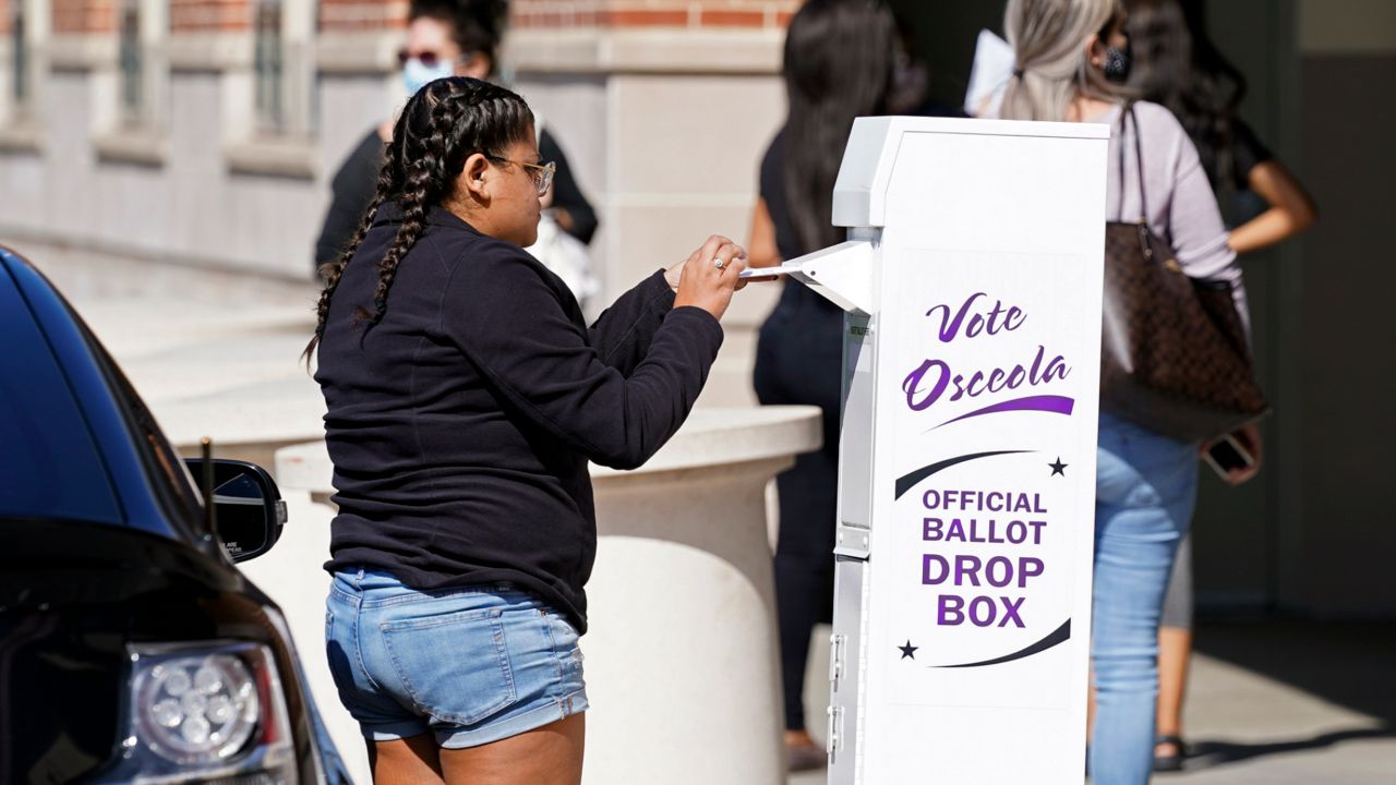 In this file photo from Monday, Nov. 2, 2020, a voter deposits her ballot in a drop box outside the Osceola County Supervisor of Elections office in Kissimmee, Fla. (AP Photo/John Raoux)