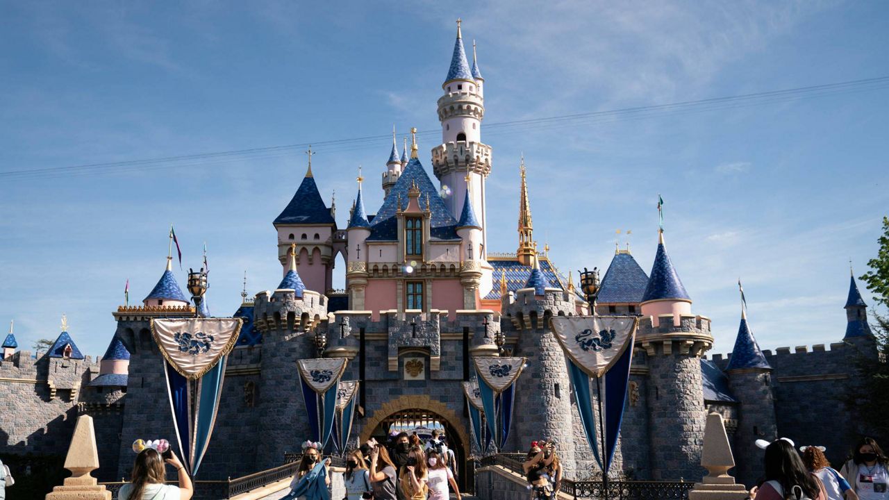 In this April 30, 2021, file photo, visitors exit The Sleeping Beauty Castle at Disneyland in Anaheim, Calif. (AP Photo/Jae C. Hong)