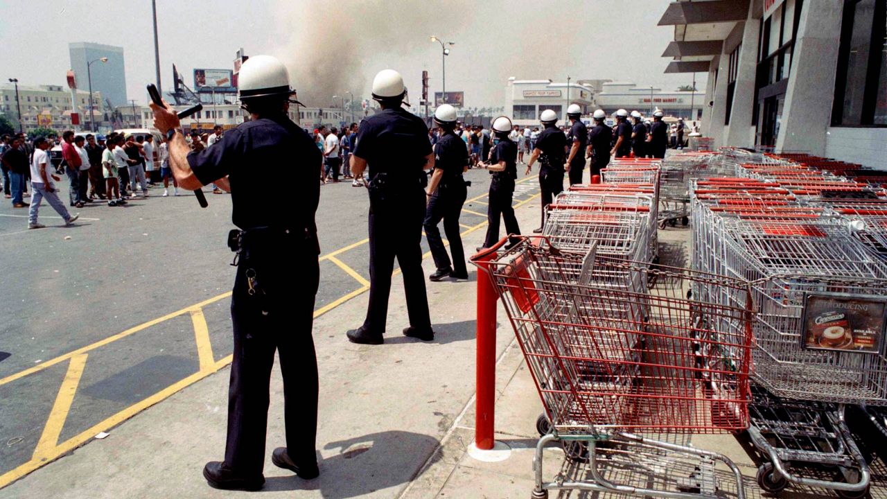 In this April 30, 1992, file photo, Los Angeles police form a line to prevent a crowd from going into a building in a day of fires and looting in LA. (AP Photo/Nick Ut)