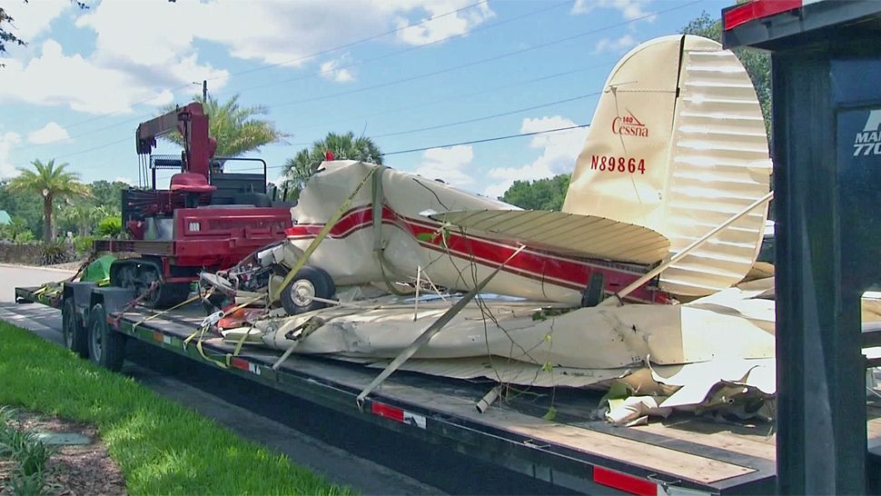 A small plane that crashed about a mile from a landing strip at the Spruce Creek Fly-In on Tuesday night is loaded onto a flatbed trailer after being recovered from heavy woods Wednesday. (Brittany Jones, staff)