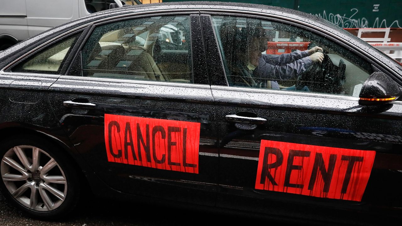 "Cancel rent" in black text on two red pieces of paper placed on the passenger-side doors of a black car.