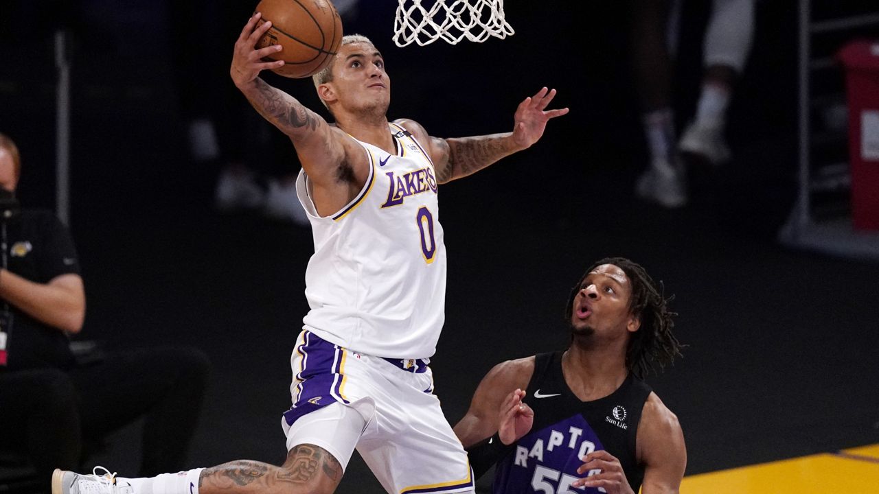 Los Angeles Lakers forward Kyle Kuzma, left, shoots as Toronto Raptors forward Freddie Gillespie defends during the first half of an NBA basketball game Sunday, May 2, 2021, in Los Angeles. (AP Photo/Mark J. Terrill)