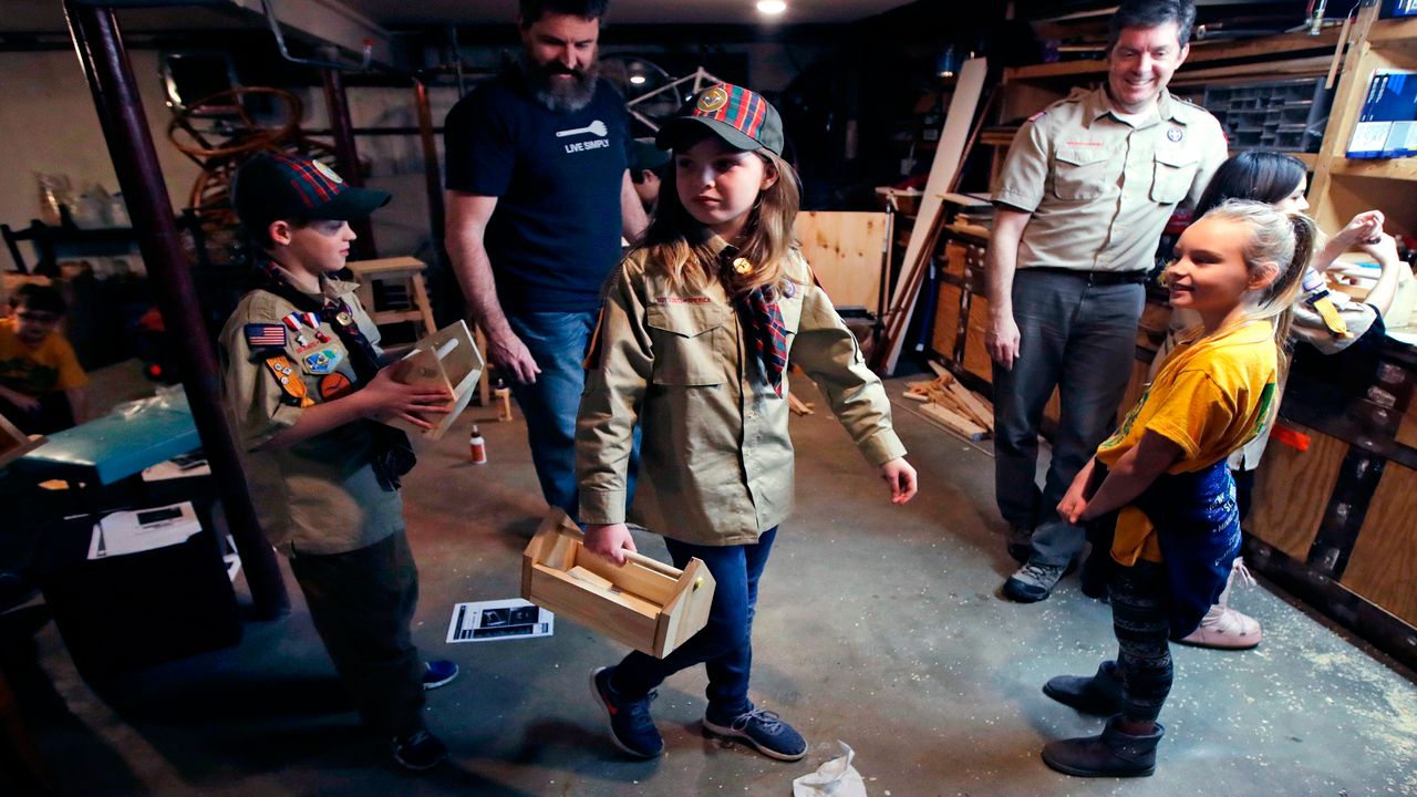 FILE - In this March 1, 2018, file photo, Tatum Weir, center, carries a tool box she built as her twin brother Ian, left, follows after a Cub Scout meeting in Madbury, N.H. Fifteen communities in New Hampshire are part of an "early adopter" program to allow girls to become Cub Scouts and eventually Boy Scouts. For 108 years, the Boy Scouts of America's flagship program for older boys has been known simply as the Boy Scouts. With girls soon entering the ranks, the BSA says that iconic name will change to “Scouts BSA.” The change will take effect in February 2019. (AP Photo/Charles Krupa, File)