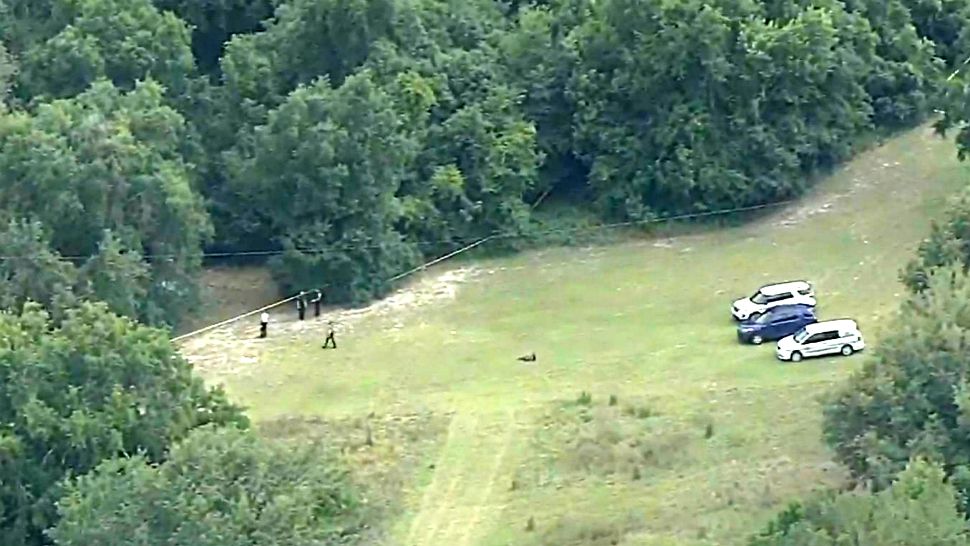Orange County Sheriff's deputies investigate the scene in the Apopka area where 2 bodies were found in woods Thursday afternoon. (Sky 13)