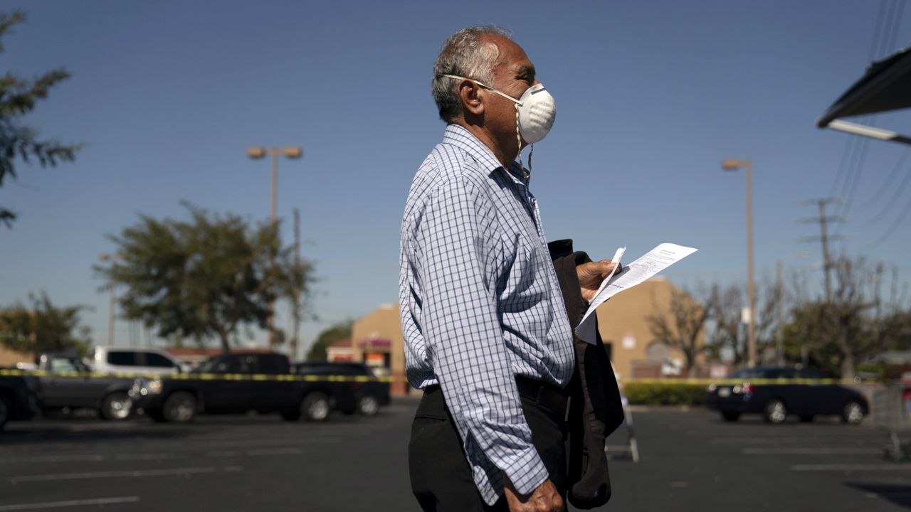 Hilario Hernandez waits to receive a dose of the Moderna COVID-19 vaccine at a mobile clinic set up in the parking lot of a shopping center in Orange, Calif., Thursday, April 29, 2021. (AP Photo/Jae C. Hong)