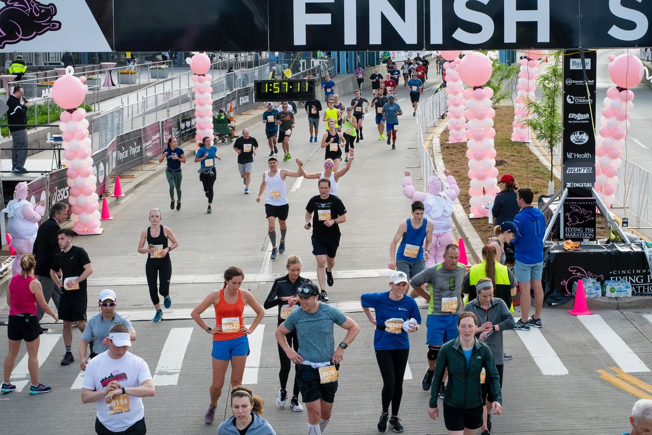 Runners cross the finish line and compose themselves after finishing a race during Flying Pig Marathon weekend. (Shae Combs/Game Day)
